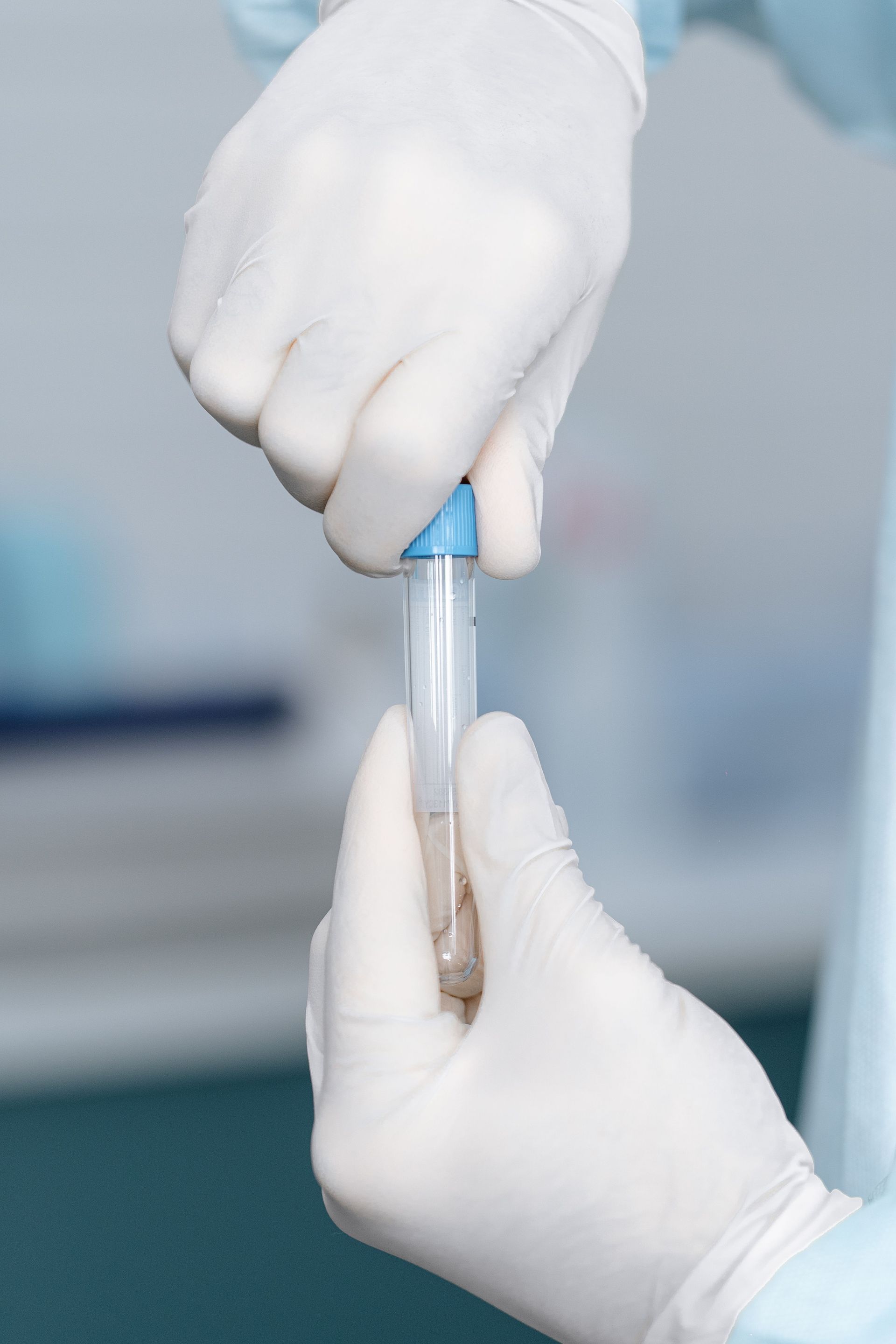 Scientist in sterile gloves handling a test tube in a lab setting, emphasizing precision.